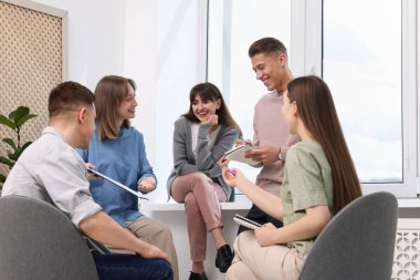 Yaşam koçluğu dersinde kapalı alanda toplantı yapan bir grup insan.