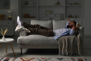 Uyum. Evdeki rahat koltukta dinlenen bir adam.