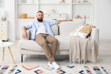 Uyum. Evdeki rahat koltukta dinlenen bir adam.