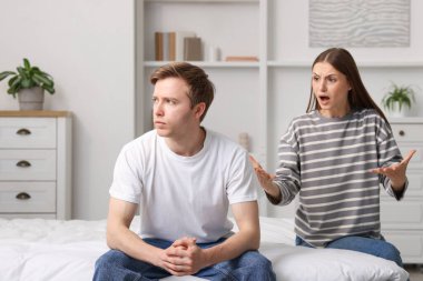 Kadın ve erkek evde yatakta kavga ediyor.