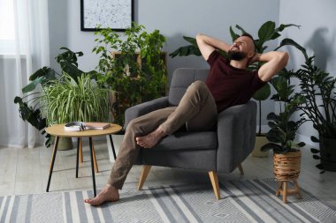 Uyum. Evdeki rahat koltukta dinlenen adam.