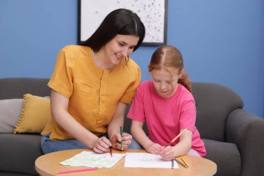 Anne kızına evde çizim yapmayı öğretiyor.