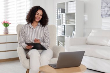 Ofiste dizüstü bilgisayarla çalışan profesyonel bir psikolog.