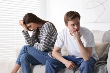 Kadın ve erkek evdeki kanepede kavga ediyorlar.