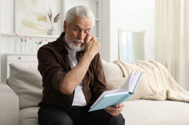 Evdeki kanepede kitap okuma sorunu olan son sınıf öğrencisi, mesaj yazma yeri.