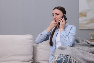 Depresyondaki kadın evdeki kanepeden ruh sağlığı için yardım hattını arıyor. Metin için boşluk