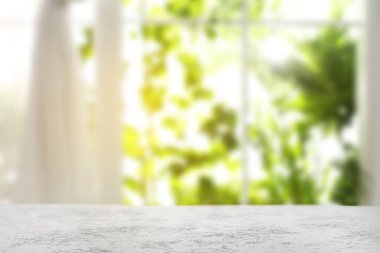 Odasında perdeler olan pencereye karşı boş beyaz masa