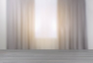 Odasında perdeler olan pencereye karşı boş ahşap masa