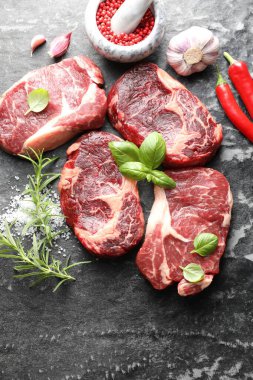 Koyu masada çiğ et ve baharat parçaları, düz yatıyordu.