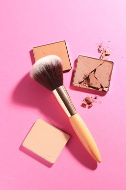 Kozmetik ürünlerinin kaplarını doldur ve pembe arka planda fırçala, düz yat