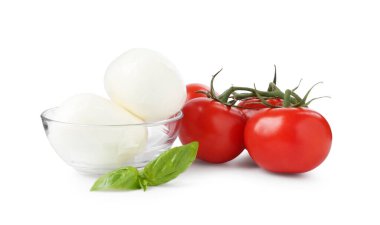 Beyaz arka planda lezzetli mozzarella peynir topları, domates ve fesleğen.