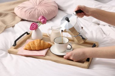 Kadın yatakta nefis bir kahvaltı yapıyor, yakın plan.