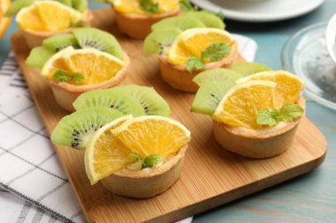 Meyveli tart ve açık mavi ahşap masada nane şekeri, yakın plan. Tatlı nefis.