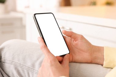 Evde modern akıllı telefon kullanan bir kadın, yakın plan.