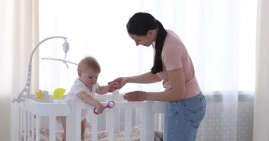 Anne evde beşikte sevimli bebeğiyle oynuyor.