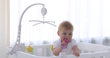 Evinde çıngıraklı beşiği olan şirin bir bebek, kamera içeri giriyor.