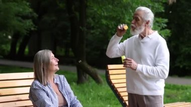 Güzel yaşlı çift parkta sabun köpüğüyle eğleniyor.
