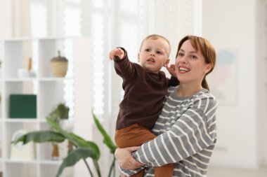 Küçük oğlu evde annesine bir şey gösteriyor. Metin için boşluk