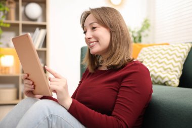 Evde tabletli bir kadın var.