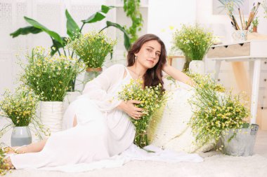 Kapalı alanda papatya çiçekleri olan güzel bir kadın.