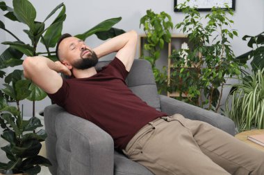 Uyum. Evdeki rahat koltukta dinlenen adam.