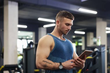 Spor merkezinde tableti olan kişisel antrenör.