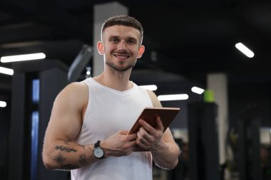 Spor merkezinde tableti olan kişisel antrenör.