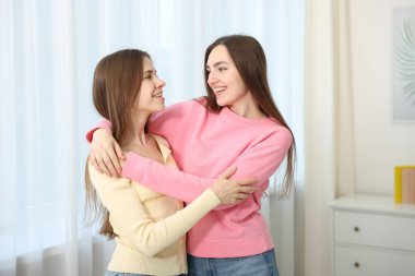 Mutlu arkadaşlar evde birbirlerine sarılıyorlar.