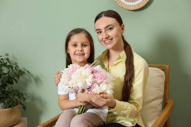 Anne ve kızı evde bir buket güzel şakayıkla