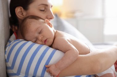 Anne yeni doğmuş bebeğini evde yatırıyor, yakın plan.