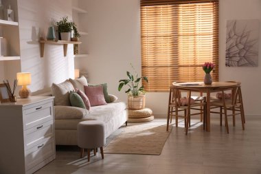 Odada rahat bir kanepe ve sandalyeli şık bir yemek masası. İç tasarım