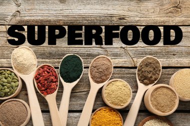 Süper yemek. Tahta masanın üzerinde farklı toz ve gıda ürünleri var.