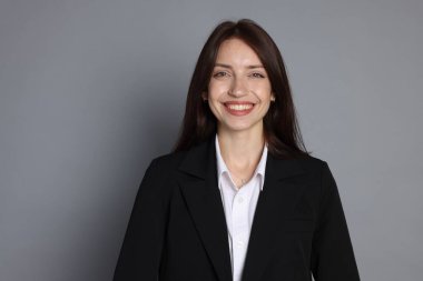 Gri arka planda takım elbiseli mutlu kadın, mesaj için boşluk