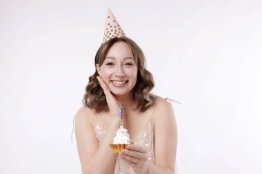 Doğum günü kutlaması. Beyaz arka planda kek yiyen kadın.