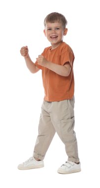 Mutlu küçük çocuk beyaz arka planda dans ediyor