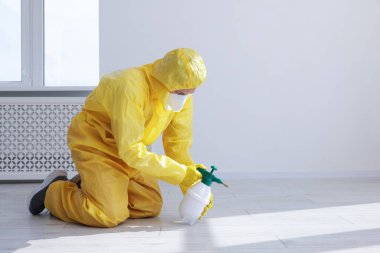 Koruyucu giysiler içinde böcek ilacı sıkan bir haşereci. Metin için boşluk