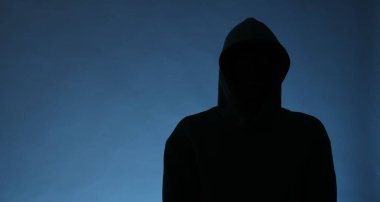 Mavi arka planda kapüşonlu isimsiz bir adamın silueti, metin için boşluk