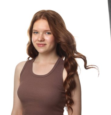 Beyaz arka planda sağlıklı dalgalı saçlı güzel bir genç kızın portresi.