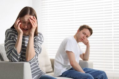 Kadın ve erkek evdeki kanepede tartışıyor, seçici bir odaklanma.