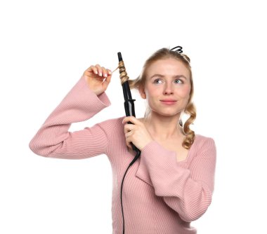 Beyaz arka planda saçını kıvıran bir kadın.