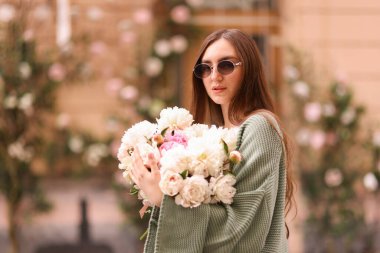 Şehir caddesinde bir buket güzel şakayığı olan çekici bir kadın. Metin için boşluk