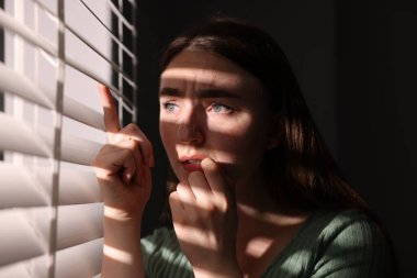 Paranoya işte. Endişeli kadın pencereden içeri bakıyor.