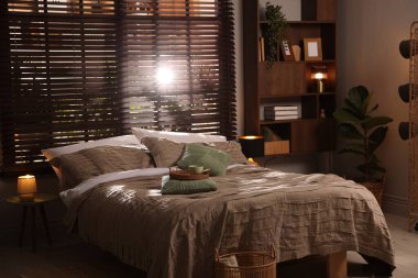 Yatak odasında güzel çarşafları olan rahat bir yatak.