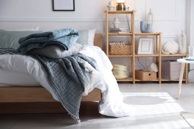 Yumuşak çarşafları olan rahat bir yatak ve şık bir odası olan bir raf. Ev tekstili