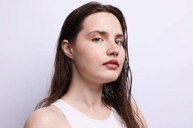 Açık gri arka planda doğal ten rengi olan güzel bir kadının portresi. Yakın plan.