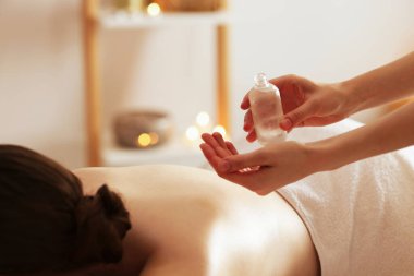 Kaplıcada kadın yağ ile masaj yaptırıyor, yakın plan.