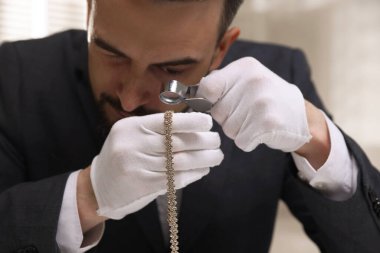 Lüks kolyeyi içeride değerlendiren, yakından gören bir eksper.