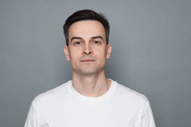 Gri arka planda tıraş olduktan sonra insan portresi