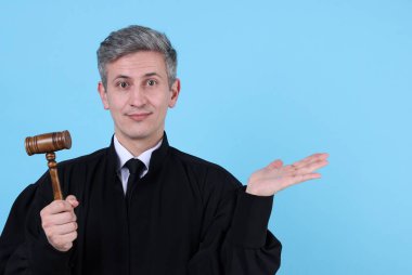 Elinde sopası olan bir yargıç açık mavi arka planda bir şey tutuyor. Metin için boşluk
