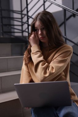 Siber zorbalık. Kapalı mekanlarda dizüstü bilgisayarı olan üzgün bir genç kız.